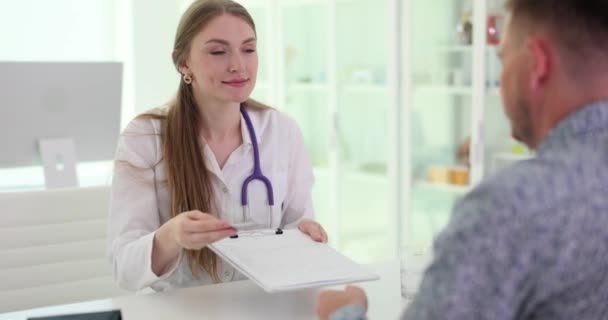 Νοσοκόμα Βοηθός Δίνει Πρόχειρο Έγγραφο Στον Ασθενή Για Βάλει Σημάδι — Αρχείο Βίντεο