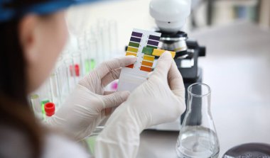 Renkleri numunelerle karşılaştıran kimyagerlerin yakın çekimleri. Laboratuvarda deney için sıvı karışımı yapan bir araştırmacı. Kimyasal deneyler konsepti