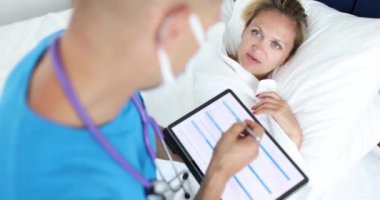Genç bayan hasta hastanede yatıp şikayette bulunuyor. Doktor tablet içinde tıbbi geçmişi yavaş çekimde kaydediyor.