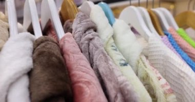 Renkli kaftanlar mağazada asılı duruyor. Yumuşak malzemelerden yapılmış ev eşyaları için satış konsepti. Ticari alışveriş merkezi