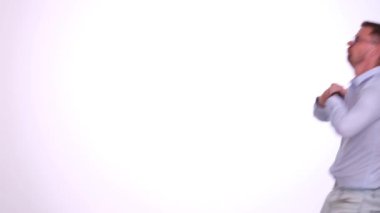 Gözlüklü genç sakallı adam dans ediyor ve stüdyoda hareket ediyor. Tişörtlü aktif biri komik vücut hareketleri yaparken eğlenir.