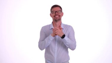 Gözlüklü genç adam el çırpıyor, gülümsüyor ve başını sallayarak onaylıyor. Sevimli erkek izleyiciler yarışmacıları alkışlarla destekliyor