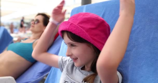 Маленькая Девочка Розовой Панаме Бросает Руки Голову Лежащие Шезлонге Рядом — стоковое видео