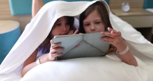 Les Écolières Jouent Sur Une Tablette Moderne Couchée Sous Une — Video