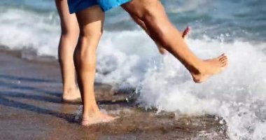 Couple stands on sand and waves splash feet. Vacation concept happiness tourists emotions