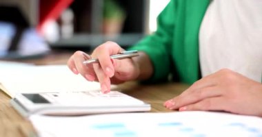 Hands of a business woman using calculator considers maths financial statistics in office. Taxation of accounting and analytical research