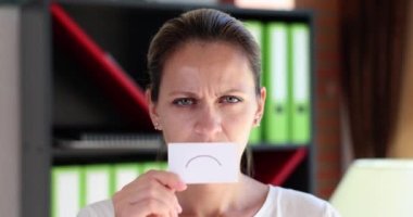 Portrait of beautiful angry woman with paper unhappy emoticon icon. Female emotions stress depression and loneliness