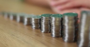 Closeup of stack of coins shaped like an ascending ladder and piggy bank. Business investment concept of savings and financial income growth