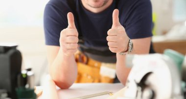 Çalışan sarı kask gösterisinde gülümseyen onaylamak başparmak ile işaret yukarıya kol resme. El ile iş DIY ilham sanayi başlangıç fikir tamir dükkanı baret endüstriyel eğitim meslek kariyer kavramı