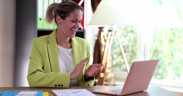 陽気な興奮ビジネス女性は良いニュースで喜びますノートパソコンを使用しています Woman Smiling Clapping Hands Talking Video Call — ストック動画