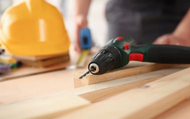 Elektrikli matkap closeup kullanarak alt kollarından. El ile iş DIY ilham iyileştirme iş tamir dükkanı sarı kask sanayi başlangıç fikir endüstriyel eğitim meslek kariyer kavramı