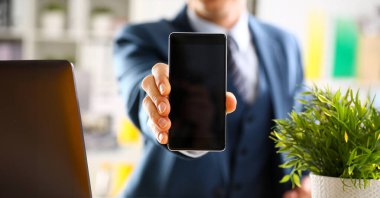 Takım elbiseli erkek kolunu göster kamera telefon ekran ekran portre. Haber mania göndermek sms okumak sohbet bağımlısı kullanın meslektaşım paylaşmak blog cıvıldamak web uygulama arama elektronik banka modern yaşam tarzı iş planı