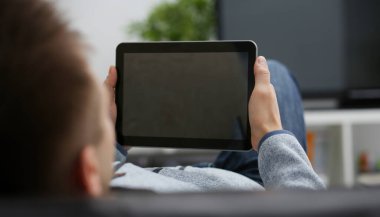 Erkek el, koltukta oturup internette sörf yaparken tablet tableti tutuyor. Müzik konseptini kapamak için uygulamayı kullanarak boş zamanı gösteren bir parmağa basmak.