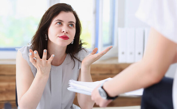 Woman business annoyed at confusion confusion pulling her hands from a lot of paper work does not understand how you can bring as many documents
