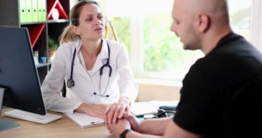 Female doctor consults depressed sad patient to clinic. Therapist talking to male client at consultation in hospital