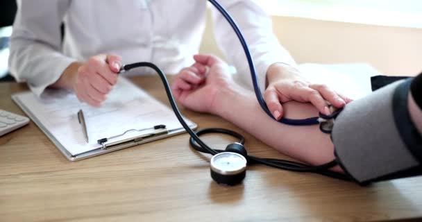 患者の血圧をチェックする医師の閉鎖 血圧モニタリングと心臓検査 — ストック動画