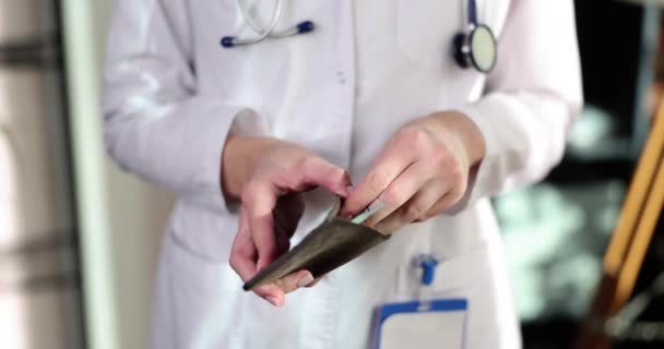 白いコートと医療用手袋の医師は手にドルで財布を保持し お金を取ります 医療サービスにおける賄賂医師の収入 — ストック動画
