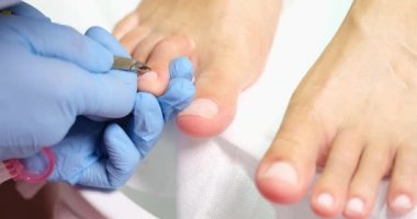 Pedicure master corrects length of nail with help of nippers. Skin and nail care