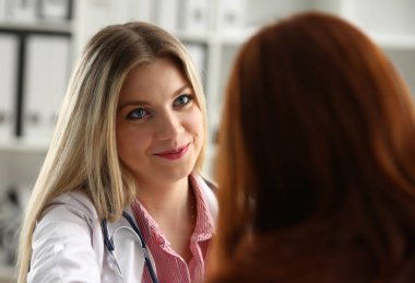 Yakışıklı samimi kadın doktor ofisinde müteşekkir Bayan hasta ile konuşmak ve ona omuz hareketi üzerinde el ile selamlıyorum. Konuksever arkadaş güven fiziksel sağlıklı yaşam sınavı mülakat kavramı