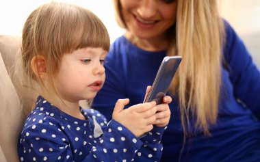 Sevimli küçük kız zemin halı anne ile baba dikey arama cep telefonu kullanın. Yaşam tarzı apps web sosyal ağ kablosuz IP telefon genel kavram