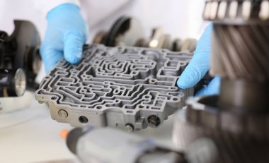 Otomatik tamir servisi otomatik vites kutuları el mavisi koruyucu eldivenleri tutar hidroblok detayı teşhis ve detaylı test aktarımını azaltır.