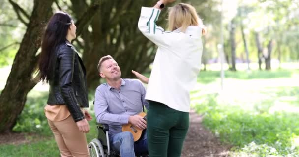 Homem Com Deficiência Cadeira Rodas Jogar Ukulele Parque Mulheres Estão — Vídeo de Stock
