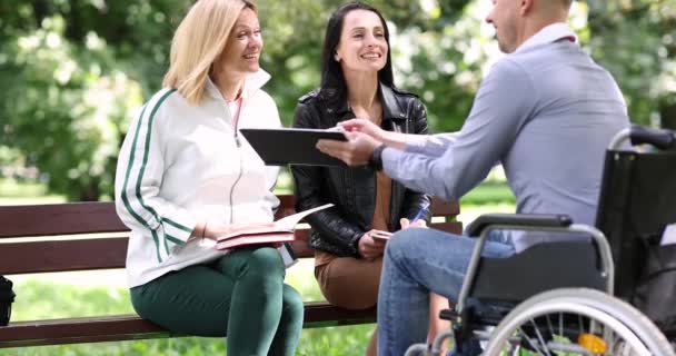 Handikappad Man Rullstol Kommunicerar Med Sina Vänner Parken Och Visar — Stockvideo