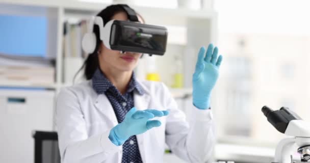 在实验室4K电影中 戴着虚拟现实眼镜的女生物学家挥手 现代科学技术概念 — 图库视频影像