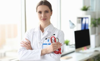Tıp bürosunda beyaz önlüklü gülümseyen kadın doktor portresi. Medina hizmet kavramı