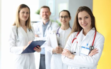 Beyaz önlüklü tıp doktorları bir arada durur. Tıbbi personel ve birleşik takım konsepti