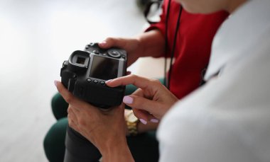 İki kadın kamerayı ellerinde tutuyor. Acemi fotoğrafçılar için çevrimiçi kurslar