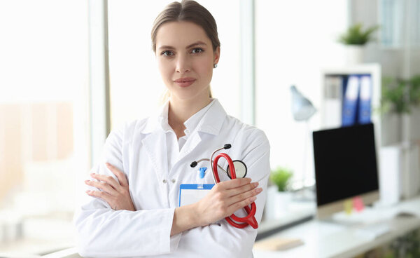Portrait of smiling female doctor in white coat in medical office. Medina services concept