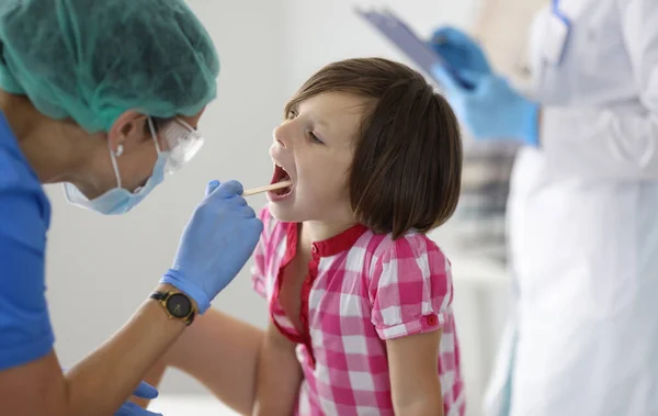 医師の診察で喉の少女が検査される 子どもの医療と健康診断の概念 — ストック写真