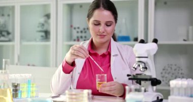 Laboratuvar asistanı cam şişeyi sarı bir sıvıyla tutuyor, araştırmaya hazırlanıyor. Denvushka öğrenci doktoru detaylı idrar testi yapıyor.