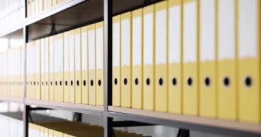 Belgeli birçok sarı klasör arşivde yakın çekimde. Belgelendirme deposu