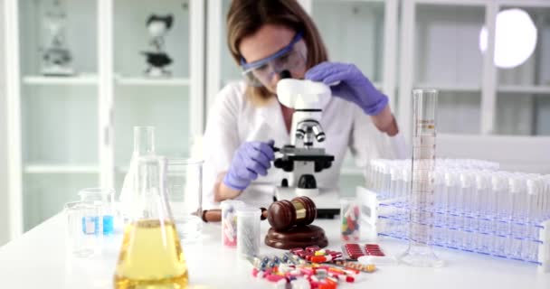 科学者の専門家は 実験室で顕微鏡を通して見ています 薬物の有効性を確認する — ストック動画