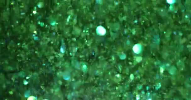 マジックダストと光沢のあるグリーンテクスチャのグリーングリッターバック お祝いのライト飛ぶ粒子は美しいボケを形作ります — ストック動画