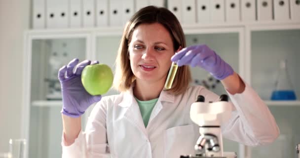 Wissenschaftlerin Hält Äpfel Und Flüssigkeit Reagenzglas Labor Untersuchung Von Apfelsaft — Stockvideo