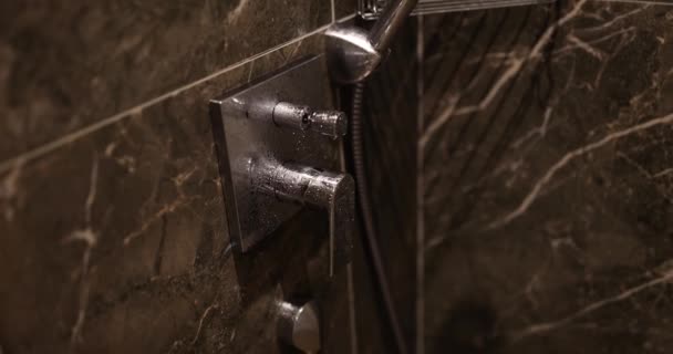 高価なバスルームに蛇口が付いている水蛇口 壁に取り付けられた水滴のシャワーが付いているコーナー シャワーのエンクロージャの細部 — ストック動画