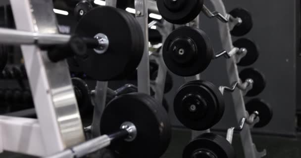 ジムの機械の黒い重量の版が付いているクロム鋼鉄棒の閉鎖 健康的なライフスタイルのためのボディトレーニングとフィットネス — ストック動画