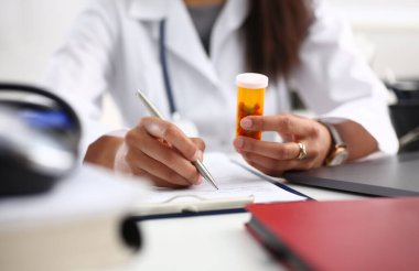 Kadın siyah tıp doktor el kavanoz hapları tutun ve hastaya worktable için reçete yazmak. Her derde deva ve hayat kurtarmak, tedavi yasal uyuşturucu mağaza konsepti reçete. Boş form kullanıma hazır