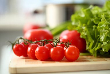 Kiraz domates kesme tahtası mutfak zemin yeşillik sağlıklı beslenme kavramı karşı yalan