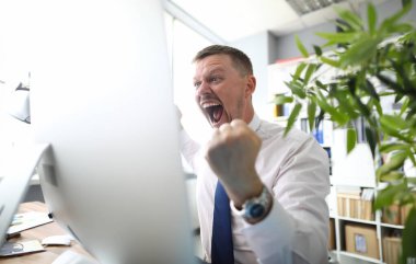 Crazy patron çığlıkları bir yumruk ile tehdit ve iş ofis arka plan karşı kamera bakar.