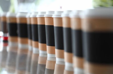 Kahveli kağıt bardak arka planda kalır. Sıcak içecek kahvaltı konsepti.