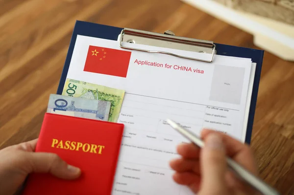 男性手拿着银笔和护照 填充中国仿制形式概念 — 图库照片