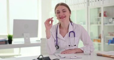 Klinikten gelecek hastalara el sallayan kadın bir tıp çalışanı. Uzman doktor ağır çekimde hastaya hoş geldin diyor.