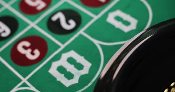 カジノで賭け金でルーレットをする 秘密のカジノで緑のテーブルクロスナンバーとホイールスピナーに賭ける 違法マネーゲームを観察する — ストック動画