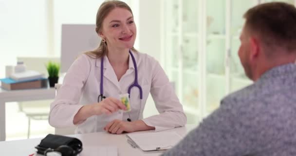 开业医生给男病人开药瓶来治病 家庭医生开病人慢动作处方 — 图库视频影像