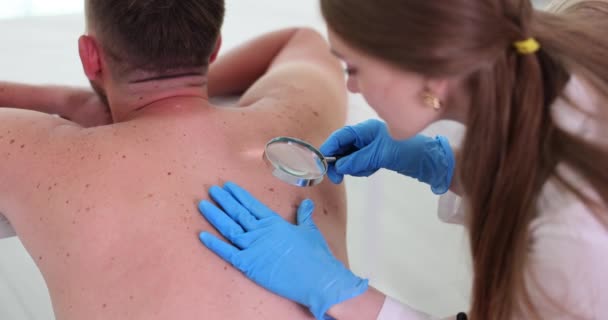 Especialista Examinando Paciente Vuelta Para Papilomas Clínica Dermatólogo Utiliza Lupa — Vídeo de stock