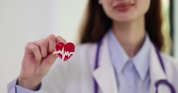 医生兼心脏科医生持有带有脉线的小型心脏模型徽章 私人诊所体位慢动作听诊器的心脏科医生 — 图库视频影像